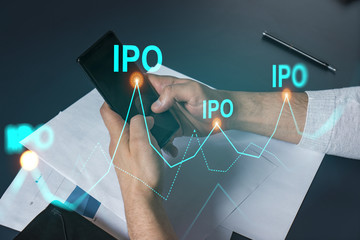 Man using phone. Hands typing smartphone. Double exposure with ipo hologram. Close up. Financial graph and analysis concept. Investment.