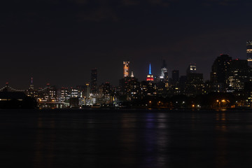 Fototapeta na wymiar Dark Nighttime Roosevelt Island and Manhattan Skyline along the East River in New York City