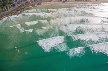 Cape Town, Western Cape / South Africa - 06/30/2020: Aerial photo of surfer and waves at Muizenberg Beach