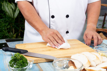 Chef cleaning wooden broad with tissue paper