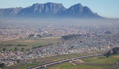 Cape Town, Western Cape / South Africa - 07/24/2020: Aerial photo of N2 and townships with Gugulethu Cemetry and Table Mountain in the background