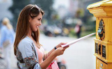 Young woman sending a folder and documents via mailbox. Business, lifestyle concept