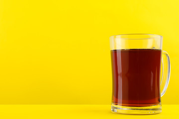 Delicious homemade kvass in glass mug on yellow background. Space for text