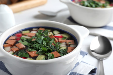 Delicious cold okroshka with kvass served on table, closeup. Traditional Russian summer soup