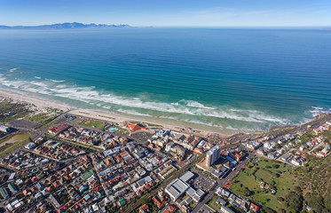 Cape Town, Western Cape / South Africa - 07/24/2020: Aerial photo of surfers and waves at Muizenberg Beach