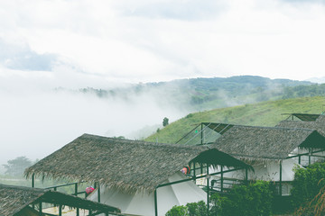 High voltage transmission towers on mountain with fog.