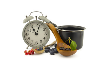 Culinary still life with clock, pot and berries