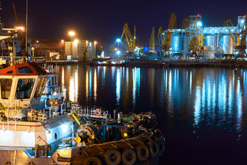 view of the industrial port at night - ships waiting for loading and unloading, cargo transportation by sea