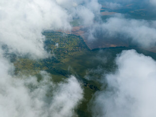 Fototapeta premium High flight in the clouds over agricultural fields.