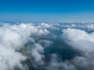 High flight in the clouds over agricultural fields.