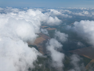High flight in the clouds over agricultural fields.