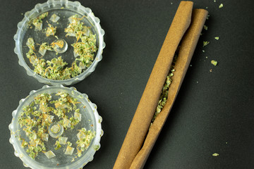 Flat lay of cannabis blunt and marijuana in grinder