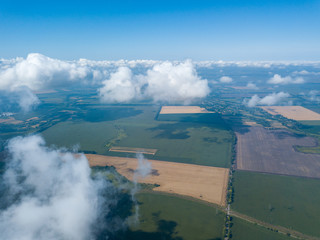 High flight in the clouds over agricultural fields.
