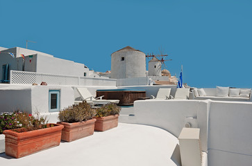 The unidentified building of Oia with windmill at background on Santorini, Greece