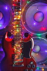abstract guitar with festive Christmas lights and music speakers