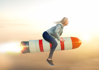 Business Frau auf Rakete fliegt Richtung Sonnenaufgang