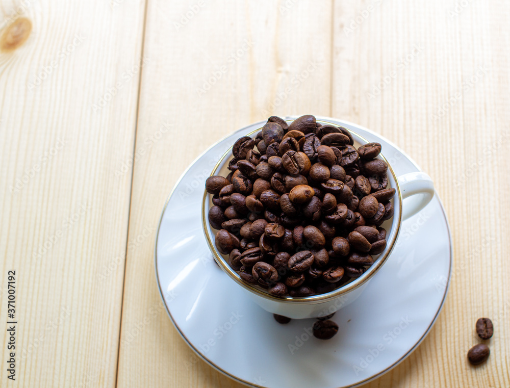 Poster white mug with cup of coffee beans on wooden background with selective focus and crop fragment