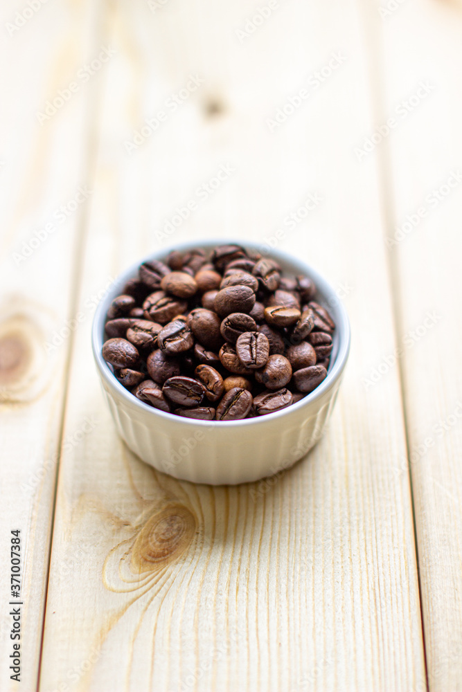 Poster white mug with cup of coffee beans on wooden background with selective focus and crop fragment