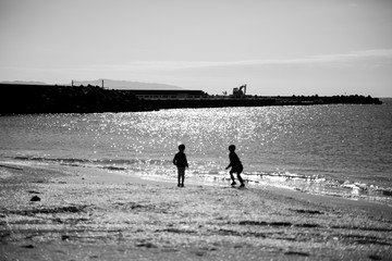 Fototapeta na wymiar 冬の海で遊ぶ子供達