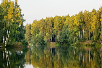 Beautiful landscape on the river with reflection during sunset. Silence and tranquility in nature, reuniting with nature, relaxation. Rural tourism and recreation concept
