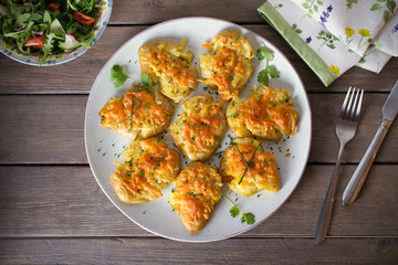 Smashed new baby potatoes with garlic butter and cheese on wooden background close up. Clean eating. Flat lay, overhead