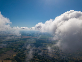 Obraz premium High flight in the clouds over agricultural fields.