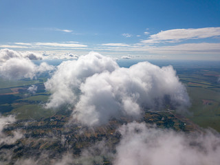 High flight in the clouds over agricultural fields.