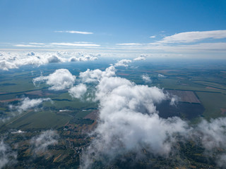 Fototapeta premium High flight in the clouds over agricultural fields.