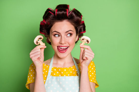 Close up photo positive retro style girl hold slice mushrooms lick lips want eat tasty dinner lunch wear stylish trendy yellow dotted dress skier hair curlers isolated green color background