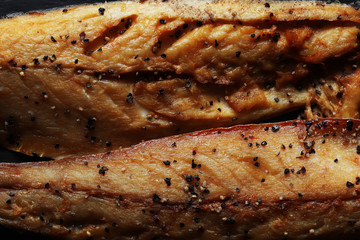 Obraz na płótnie Canvas Photography of two fillets of smoked mackerel with ground black pepper for food illustrations