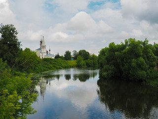 photo of the wide Suzdal river near Russian white stone Orthodox churches