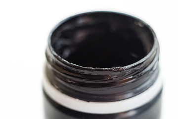 A can of paint on a white isolated background. Black paint in a can. Gouache and acrylic.