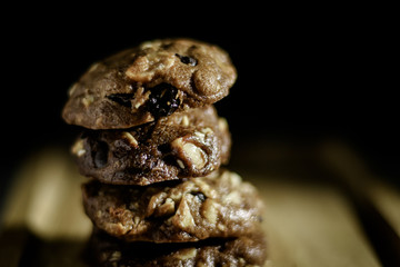 Homemade sweet chocolate cookies on wooden table with black background