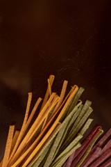 Dry pasta of different colors, yellow with turmeric, pink with storm, green with spinach, Italian cuisine, telanatelle