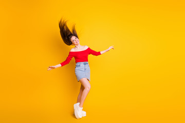 Fototapeta na wymiar Full body size photo of cute adorable funky young girl raised hands air hair shiny smiling wear shirt open shoulders denim mini skirt sneakers isolated bright yellow color background
