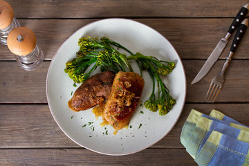 Duck breast fillets with caramelized onion and broccoli. View from above, top studio shot