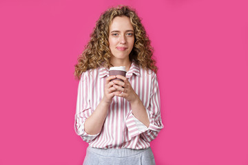 Young beautiful woman holding coffee in her hands.