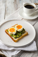 Toast with guacamole and boiled egg, avocado toast with coffee cup
