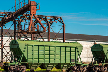 Green loading railway wagon standing near the elevator