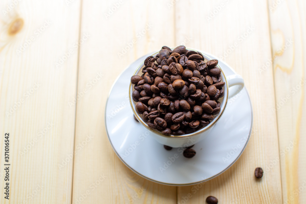 Poster white mug with cup of coffee beans on wooden background with selective focus and crop fragment