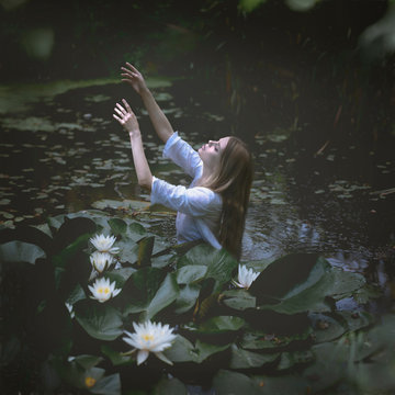 Gloomy picture of a woman drowning in dark swamp water
