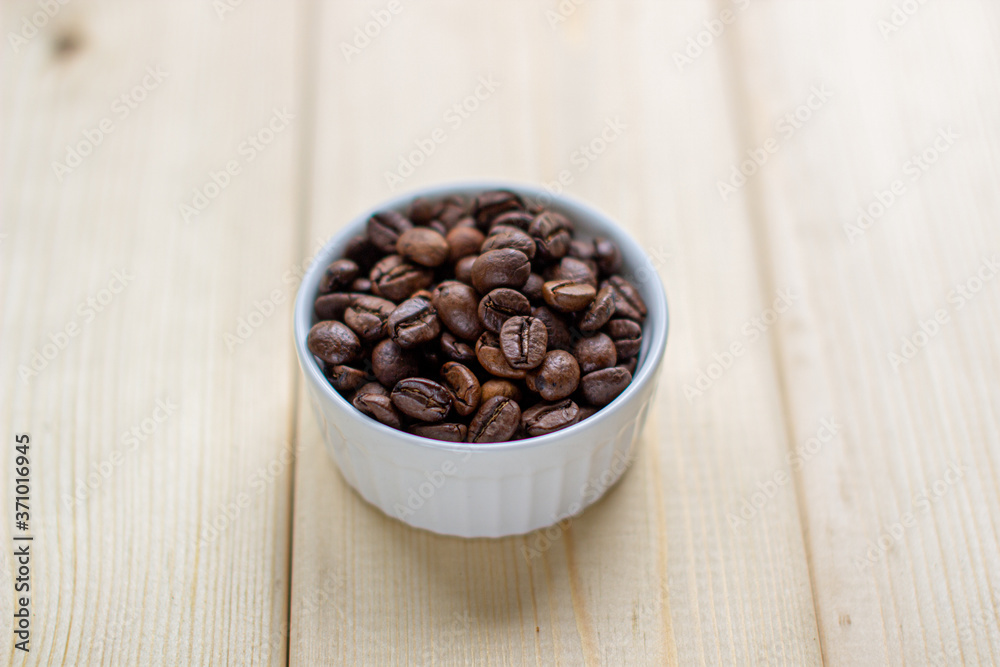 Poster white mug with cup of coffee beans on wooden background with selective focus and crop fragment