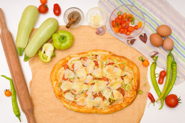 step by step recipe for cooking homemade vegan pizza with zucchini, tomatoes, peppers, mozzarella . hands of a woman preparing a pizza from the top view . light background