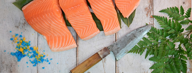 Top view of raw salmon fillets and a cooking knife.