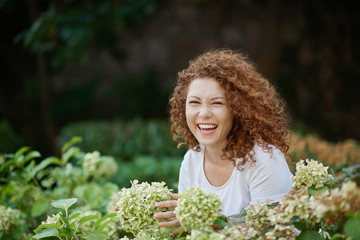 Portrait of a laughing young woman outside in a garden