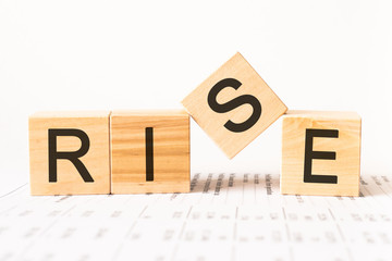 Word Rise made with wood cubes, stock image. Financial concept.