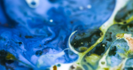 Closeup Paint with Vibrant Color Palette. Oil Mixed with Bright Blue and Yellow Dye and Paint.