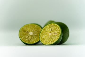 whole and half with slice of fresh green lime isolated on white background. Fresh and real tropical fruit.
