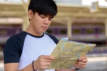 Young handsome Asian tourist man at the railway station