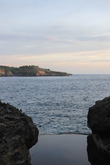 Sunset at the Angel's Billabong is natural infinity pool on Nusa Penida Island, Bali, Indonesia. Amazing  view with rocky mountains and with clear water of Indian Ocean 